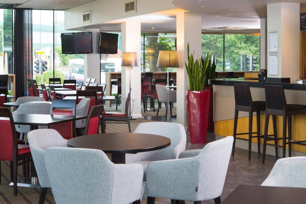 a restaurant with tables and chairs and a bar at Holiday Inn Express Bath by IHG in Bath