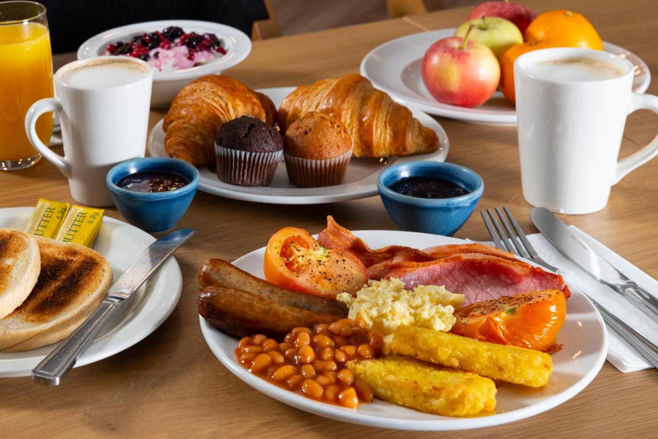 a table with plates of breakfast food on it at Holiday Inn Express Bath by IHG in Bath